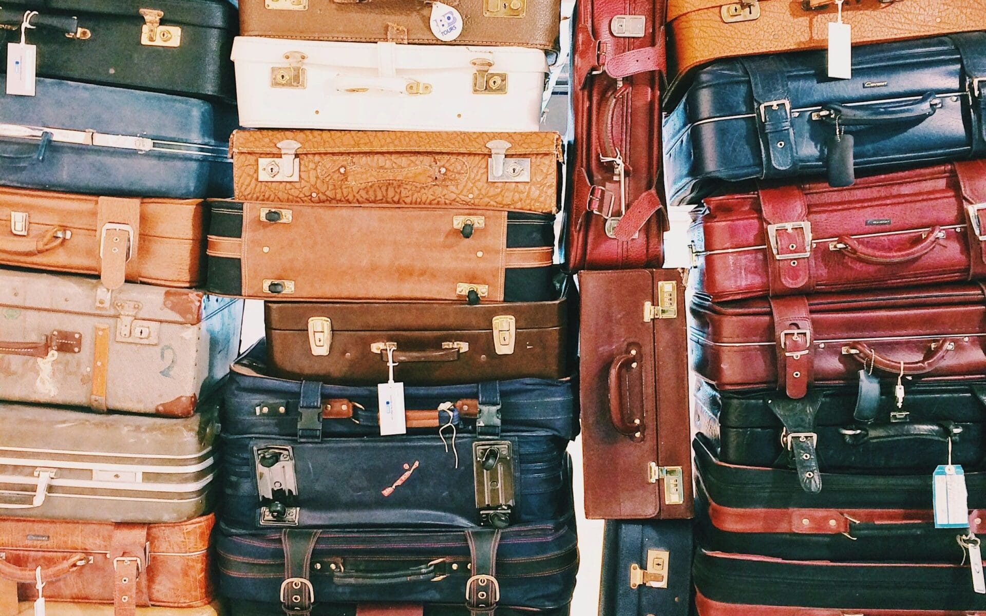 A colorful stack of vintage suitcases symbolizing travel and cultural exploration.