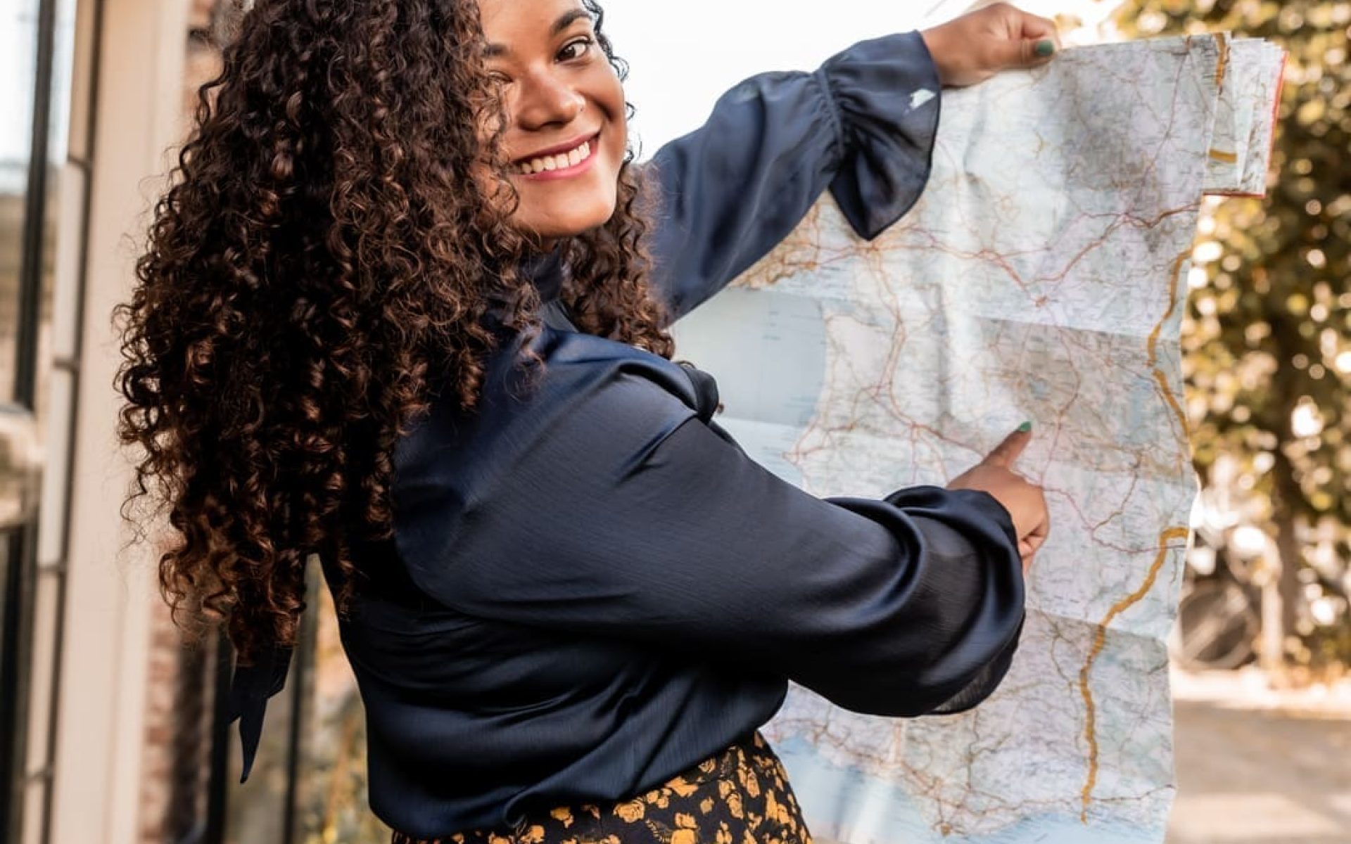 Virginia, travel specialist for solo travelers and travel buddies, holding a map and smiling
